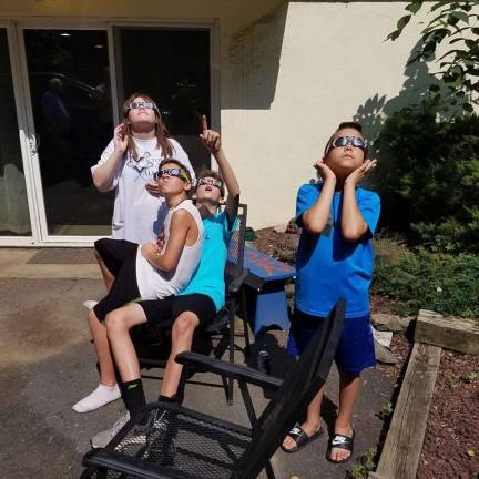 PHOTO COURTESY VICKI YANAGASophia Yanaga (far left) and her brother, Alexander (far right) watch the eclipse with friends.