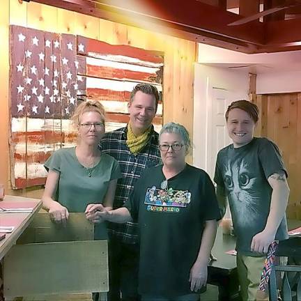 From left are siblings Louise, Albie and JoAnn Parisella with Rob Thomas, a friend and employee who was instrumental in creating the Lake House Cafe’s new location in Andover. They are standing by a wooden American flag made by Albie Parisella. (Photo by June Flyntz)