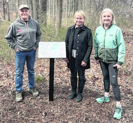 From left, Neil Saurwein, Anne Lopuch, and Christine Dunbar stand at a new sign.