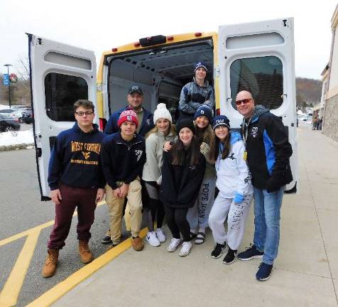 Sgt. Frank Schomp (L) and Lt. Terrence Mulligan of the Sparta Police Department were joined by volunteers from Pope John XXIII High School as they collected donations for Stuff the Bus 2018 outside the Sparta Stop and Shop on Sunday, Nov. 18, 2018. 