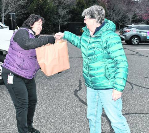 Lisa Kowalsky of Sparta hands a bag to Wendy VanGorden of the Dept. of Social Services.