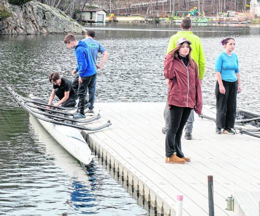 Members of the Sussex County Rowing Clu lower a canoe into the water after a recent practice. The club is made up of Students from Sparta High School and Pope John XXIII Regional High School.