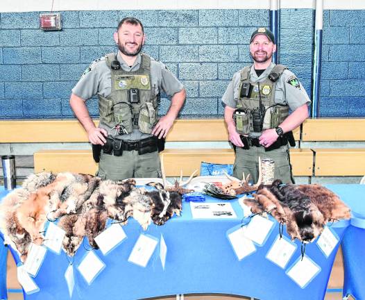 <b>Two conservation police oficers pose for a photo.</b>