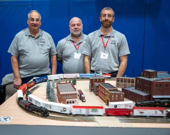 Members of the Sussex County Railroad Club stand behind a model train display.