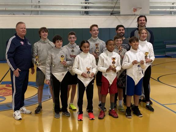 Spartans standing from left First row: Griffin Brawer, Mila Valentin, Adam Mustafa (standing first from right). Second row from left: Maestro Trudnos, Benjamin Giralt (gold medalist).