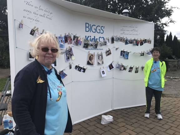 Friends of Karen Ann Quinlan Hospice stand in front of the memory photo wall that was introduced to the walk last year and sponsored by BIGGS Kids. Participants are encouraged to bring a photo of their loved one to be displayed on the wall. Photo provided