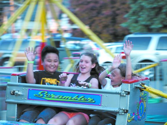 Left to right: Aidan Esperance, 10, of Jefferson, Carly Studt, 9, of Lafayette and Rebecca Yetter, 10, of Sparta, on the Scrambler at the Our Lady of the Lake carnival.