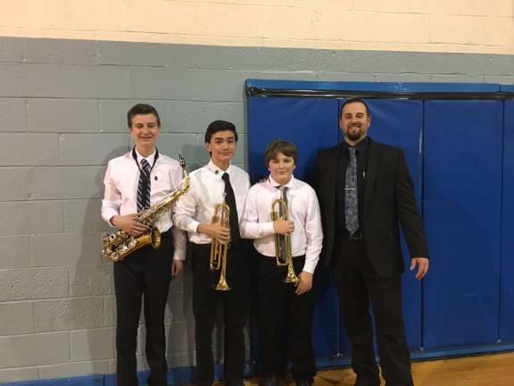 From left, Devlin K. alto sax, Jacen N. trumpet, Dylan J. trumpet and teacher/band director Dante Cornella