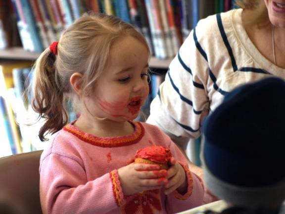 Nicole Wilson, 2, of Sparta enjoys a cupcake during Elmo&Ocirc;&oslash;&frac12;s birthday observance in the Sparta Library Friday morning.