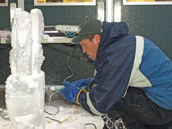 Chad Gasiorek, culinary arts instructor, uses a die grinder to carve details in an ice sculpture Thursday morning.