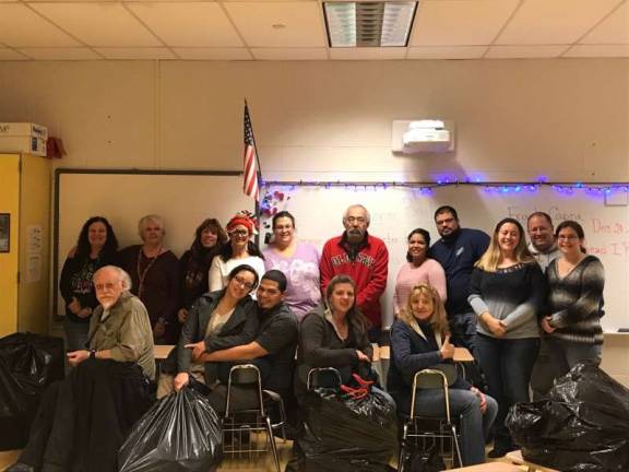 Project Help volunteers &#x2014; the first four women in the back row from the left, Karen Riernsten, Sandy Mitchell, Michelle Gray and Elizabeth Wizniewski &#x2014; pose with veterans and their families at the Santa Shop Photo provided
