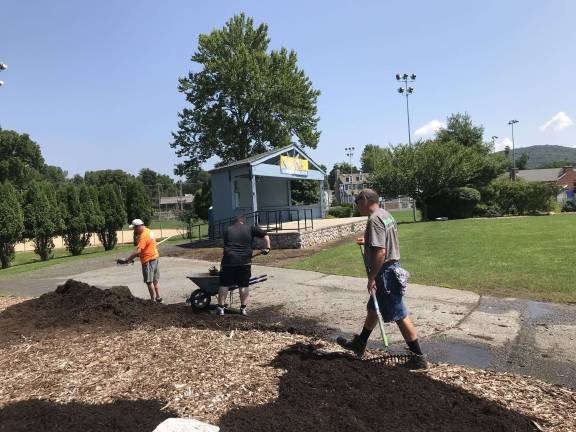 Ray Shupak, Ethan Harby, and Glen Vetrano spreading mulch at Dykstra Park near the Sparta UNICO Columbus monument.