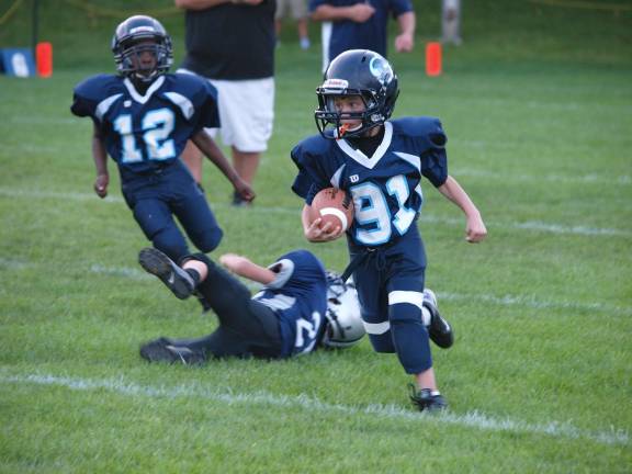 Rumble Division Sparta Spartans ball carrier Lincoln Brill (91)avades a Kittatinny Cougar defender and heads down field. Brill scored a touchdown on this run. Football fans packed Ungerman Field in Sparta, N.J. on Friday August 30, 2013. Sparta youth teams took on several teams from neighboring towns in exhibition games. The evening also featured a special recognition of military veterans.