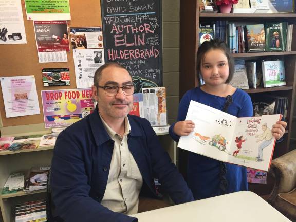 Author and illustrator David Soman signs a copy of his newest release "Ladybug Girl and Her Papa" for Winter Karl-Gruswitz.