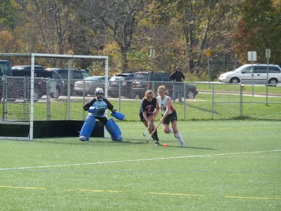 SHS Goalie Jacqueline Quinn and teammate Emily Melberger (in navy) defend the goal against an aggressive opponent.