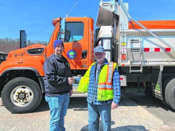 Scott House, left, director of the county Division of Public Works, shakes hands with Ernest Katzenstein.