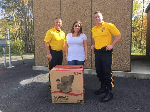 From left, Sparta Police Cpl. Kurt Morris with car seat raffle winner Erin Farley and Sparta Officer Jeff Mc Carrick. Photo provided by Sparta police.