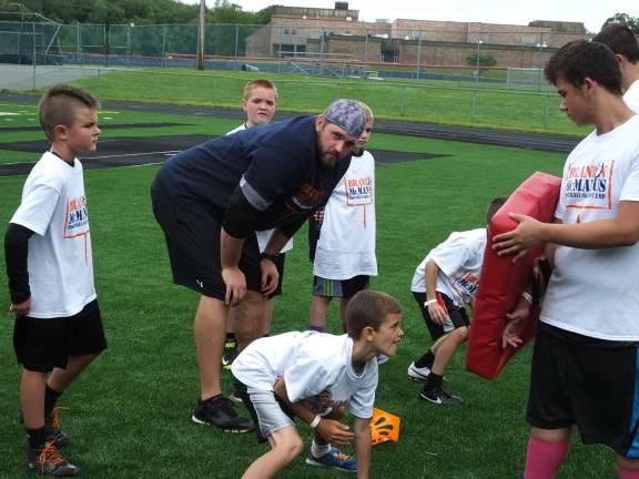 Former Detroit Lions player Patrick Boyle presides over blocking drills.