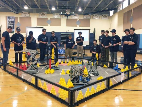 Students working together with their robots in the final matches to stack cones and score points Photos by Liam Oakes