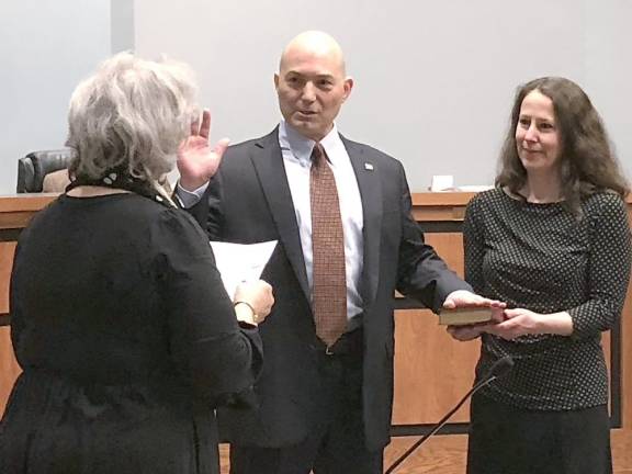 Roxanne Landy, left, Sparta deputy registrar/clerk, administers the oath of office to Councilman Dean Blumetti as his wife, Janet, holds the Bible.