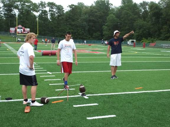 Kevin Utter, of Sussex County Technical School, and Anthony Littelwood, of Upper Merion High School, listen as at far right Denver Broncos football player Brandon McManus instructs.