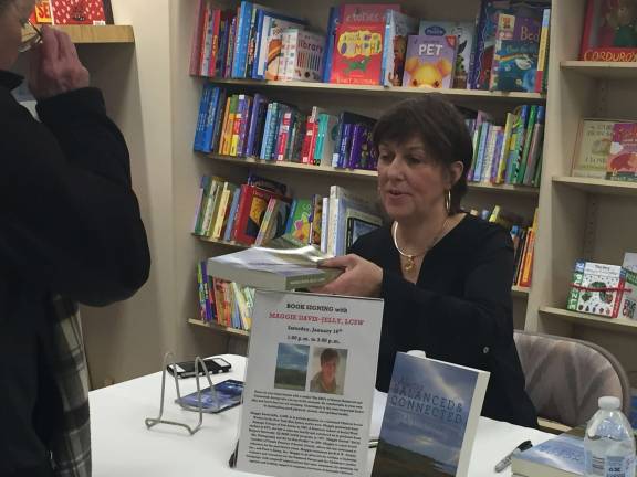 Maggie Davis-Jelly signs copies of her book.