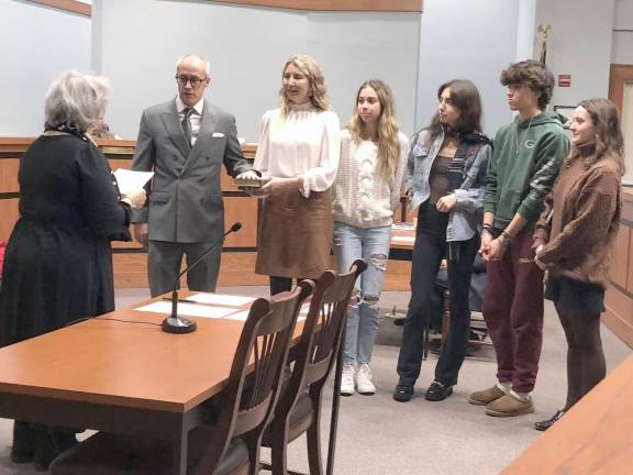 Roxanne Landy, left, Sparta deputy registrar/clerk, administers the oath of office to Neill Clark, With him are his wife, Alexandra Miller Clark, and, from left, his stepdaughters Julia and Sarah Miller, his stepson George Miller and his daughter Avery Clark.