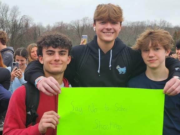 From left, sophomores Adam Teixeira, Sean Kettle and Chris Verney hold a sign that says, ‘Say No To School Shooting.’