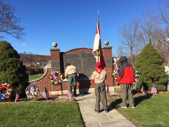 Boy Scouts present flowers at the memorial in front of Sparta VFW Post 7248 as part of the Nov. 11, 2018 Veterans Day ceremony.