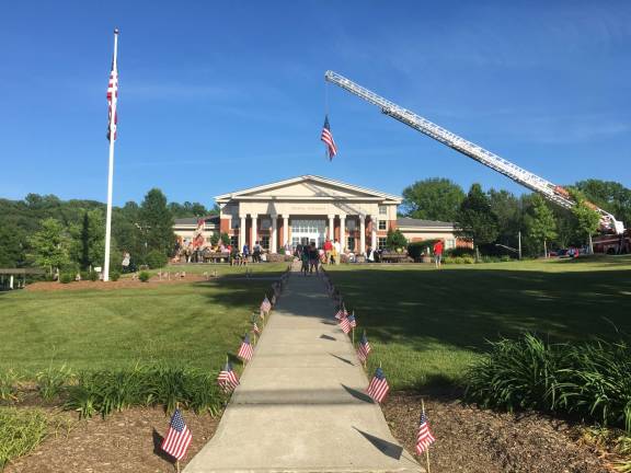 Old Glory suspended from a firetruck ladder over the entrance to the Sparta municipal building at Tuesday's Flag Day celebration Photos by Amy Shewchuk