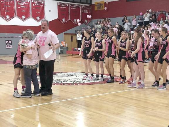 A Wallkill Valley Regional High School student hugs Diane Redner, who has breast cancer, at the annual Pretty in Pink game at High Point Regional High School on Saturday, Jan. 14. Redner’s brother is Wallkill Valley girls basketball coach Earl Hornyak, standing behind them. (Photos by Kathy Shwiff)