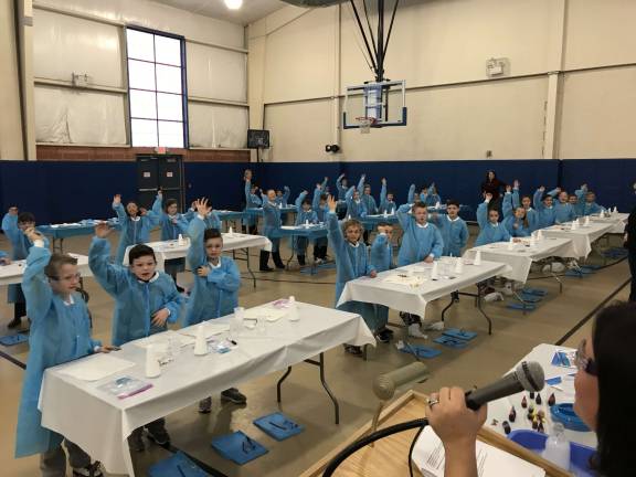 Reverend Brown second-grade students raise their hands as they look to answer a question from Shannon Gunter, an employee of Bayer, during STEM Day on Friday at Reverend George A. Brown Memorial School in Sparta.