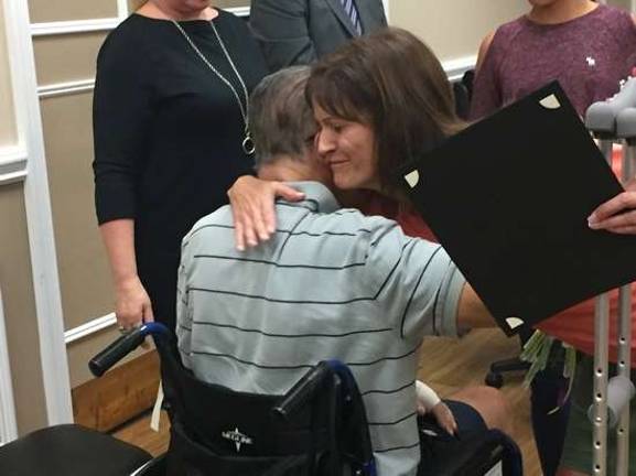 Monica Transier greets Tom Heller with a hug.