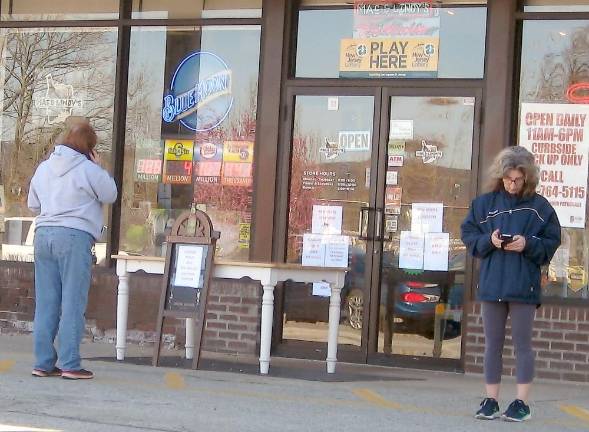 Customers distance themselves from one another as they wait outside Mac and Lindy's in the Acme Plaza in Vernon for their orders. Patrons are not allowed in stores for safety reasons.