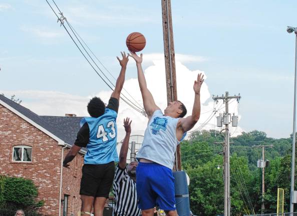 SB1 Team Falk's Ivan Hicks (43) and Team Smalley's Almin Hodzic reach for the ball during a tip-off to start the game. Team Smalley won the championship for the second year in a row, defeating Team Falk, 75-61. (Photo by George Leroy Hunter)