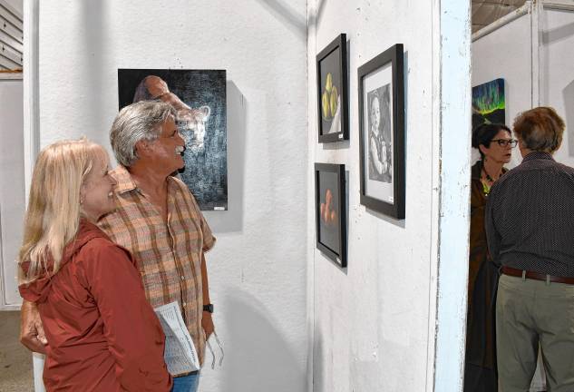<b>Judy and Rick Nothstine of Andover look at the art.</b>