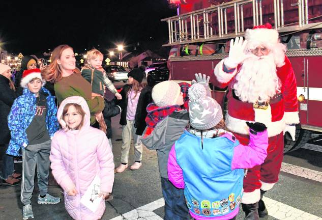 Santa Claus greets children at the tree lighting.