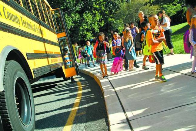Children pile off the bus.