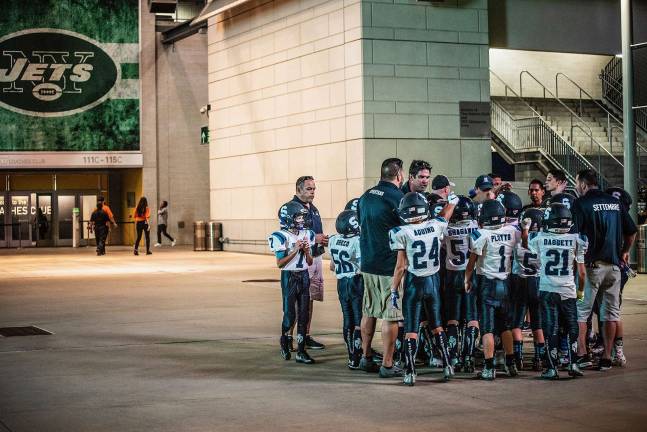 The 5th grade boys get a last-minute pep talk from the coaches before entering the stadium