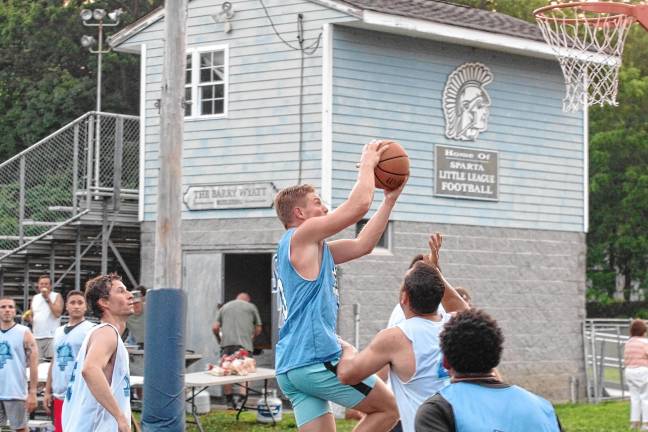 Team Falk’s captain Shawn Falk raises the ball toward the hoop in a game against Team Smalley.