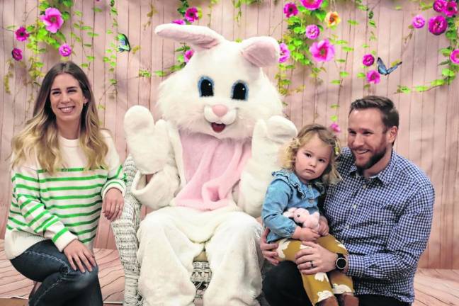 Emmerson Trainor and her parents pose with the Easter Bunny.