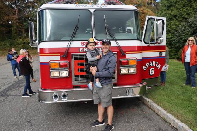 SF2 Peter Desarro and his son Anthony pose in front of a firetruck.