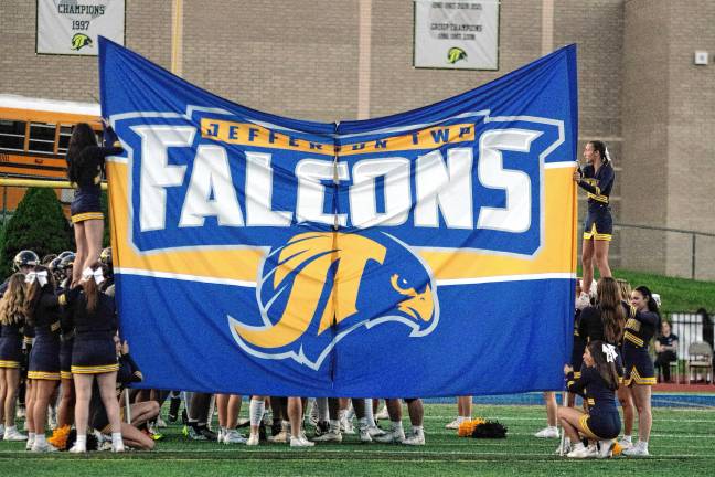 <b>The Jefferson Township High School cheerleaders hold a breakaway banner before the football team makes its entrance.</b>