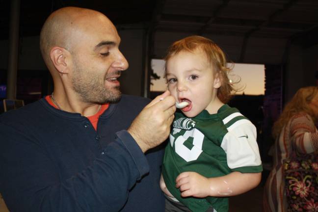 Attendee Ron Grano gives his son Samson a taste of ice cream at last year's event Photo by Rose Sgarlato