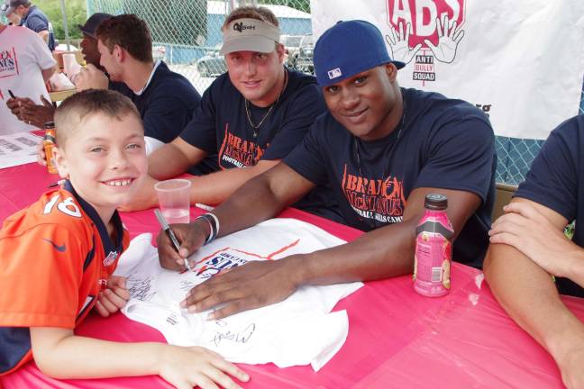 Eight-year-old Gavin Lios, of Stanhope, with Jacksonville Jaguars offensive tackle Cody Booth and the Philadelphia Eagles player Marcus Green.