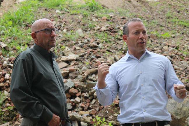 U.S. Rep. Josh Gottheimer, right, assesses the waste pile alongside Vernon Mayor Harry Shortway, Jr., left. In the background, rebar, cement, asphalt and rusted piping can be seen mixed in among the waste.