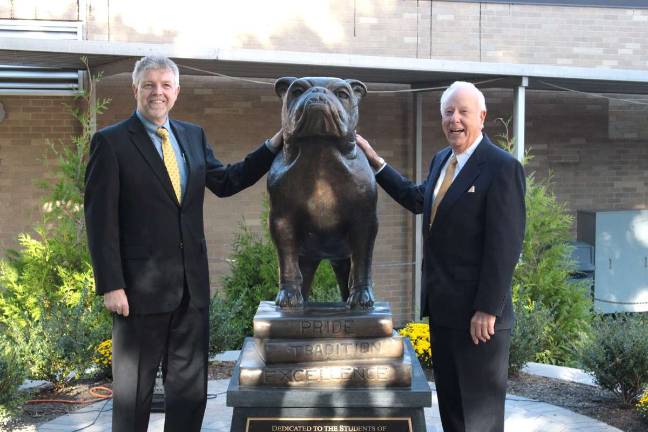 Butler High School Principal Martin Wall, stands with Bob Nicholson, 1945 BHS Alumni, next to the bronze bulldog at the dedication ceremony in October.