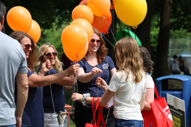 Junior Women's Club volunteers Rachel Lucas, Janet Mammolo and Janie Carson give out balloons to passers-by. Carson said, "Baloons are instant smile makers, and people of all ages ask for them." (Photos by Shannon Kuratli)