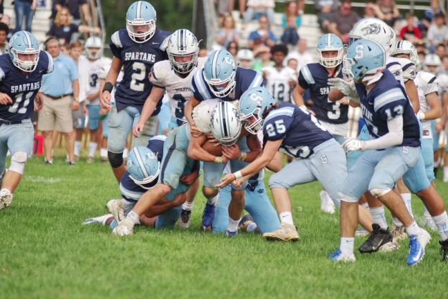 A West Morris Central ball carrier is set upon by Sparta defenders.