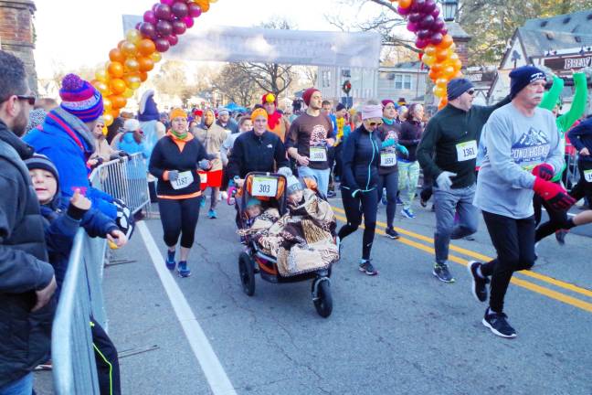 Jaime Degroat of Port Jervis, New York pushes a stroller of little ones along the course of the 5K.
